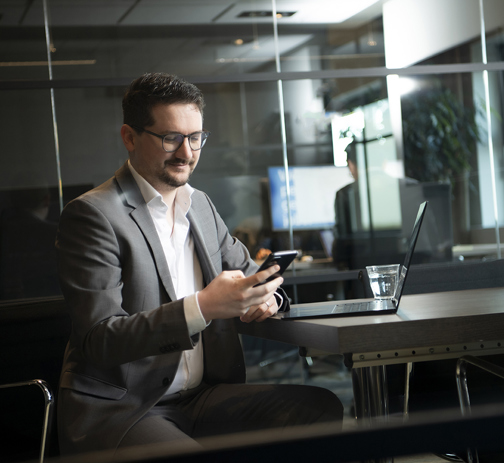 A male RGF Staffing employee looking at his phone in a meeting room