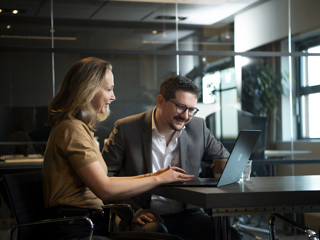 A picture of two colleagues looking at a laptop screen in the office (2)