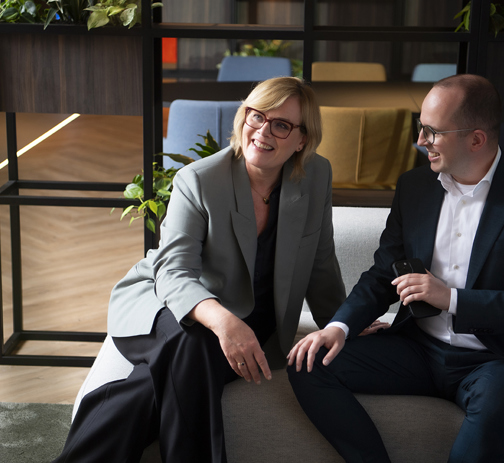 Two colleagues sitting on a couch in the office